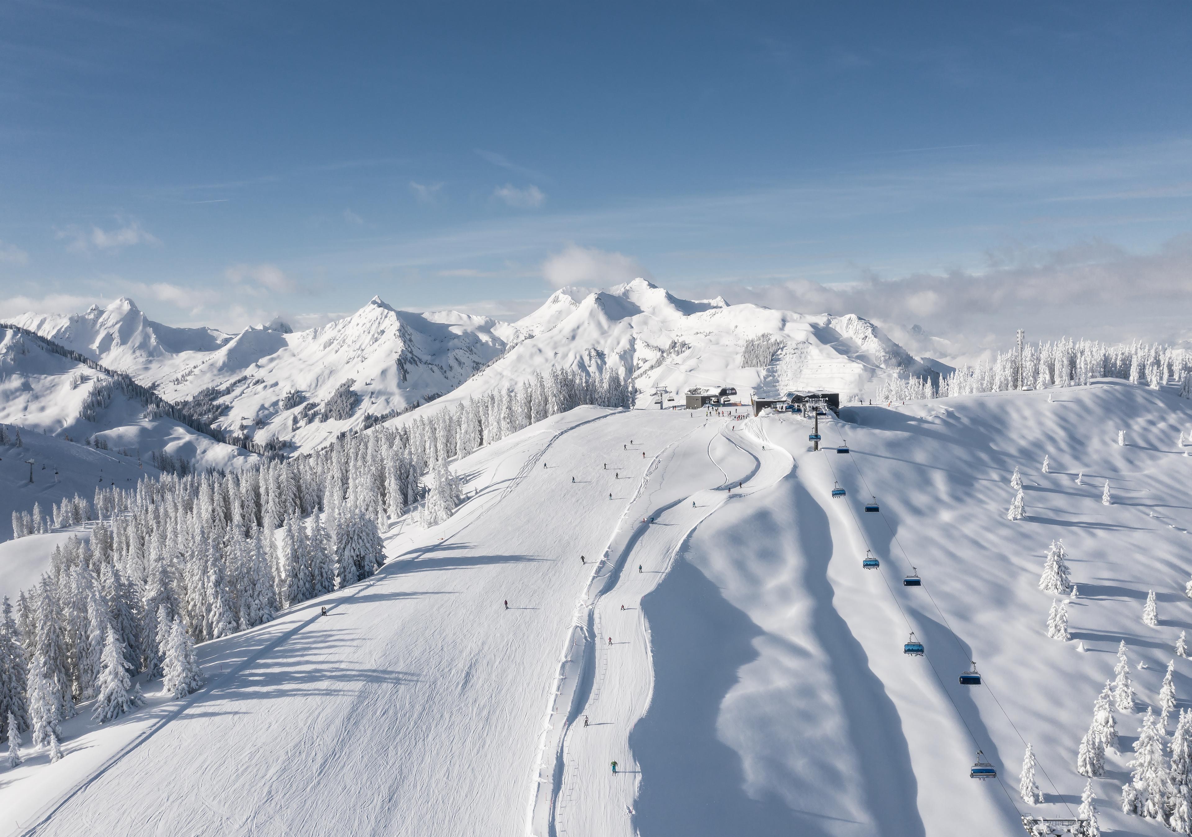 Skiiers skiing down picturesque ski slope in Austria