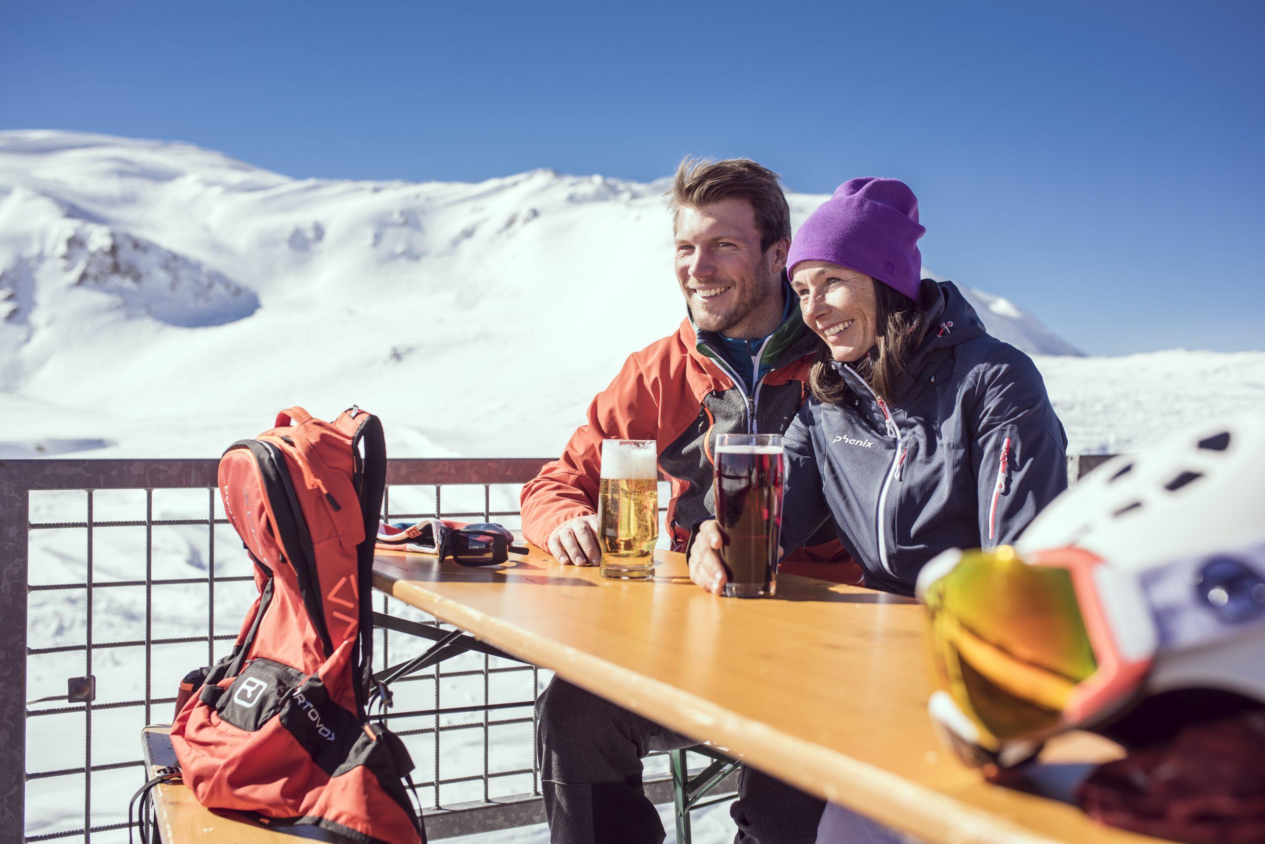 couple enjoying a drink on a terrace in the sun